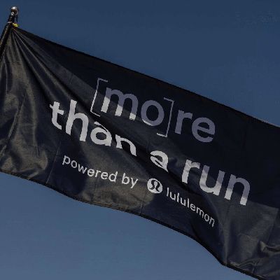 Image of a black flag that says in white text "[mo]re than a run - powered by lululemon".